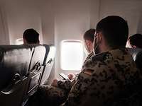 Der Flug nach Bamako Soldaten sitzen in einem Flugzeug und schauen zur rechten Seite aus dem Fenster hinaus