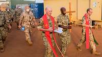 Auf dem Weg zur nächsten Station Militärpfarrer Plümper und Father Paul McCourt und ein Soldat mit dem Kreuz