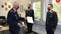 Ein Soldat erhält eine Urkunde überreicht.