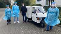 Das vierköpfige Testteam des Testzentrums Rhein-Erft aus Hürth in Sicherheitsmontur. Als Testmobil dient ein Kleintransporter