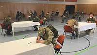 Der Wartebereich in der Turnhalle. Ausländische Soldaten warten auf ihre Testung
