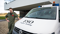 Gabriel steht neben dem Flight Safety Auto des Flugsicherheitsoffiziers