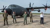 Vor einer C-130J Hercules steht ein Team aus Deutschen und Franzosen 