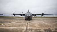 Ein Transportflugzeug C-130J Hercules steht auf einer Platte. Zu sehen ist sie es frontal von vorn.