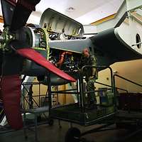 Ein Soldat steht auf einer Hebebühne an einem Triebwerkstrainer