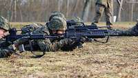 Mehrere Soldaten liegen auf dem Boden und zielen mit ihren Gewehren.