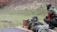 Ein Soldat liegt auf dem Boden und zielt liegend aufgelegt mit dem Gewehr G36.