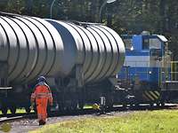 Eisenbahnkesselwagen hinter der Rangierlok der FBG Die blau-weiße Diesellok der FBG rangiert einen Eisenbahnkesselwagen.