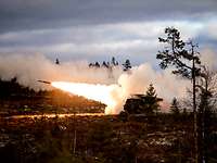 Mittlere Artillerie Raketensystem II Aus einem großen Militärfahrzeug startet eine Rakete mit einem großen Feuerstrahl.