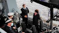 Annegret Kramp-Karrenbauer Fregatte Sachsen-Anhalt Einsatzboot Eine Frau mit kurzen braunen Haaren in dunkelblauer Jacke im Gespräch mit einem Marinesoldaten in blauer Arbeitsuniform.