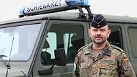 Ein Mann steht an einem Sanitätsfahrzeug der Bundeswehr