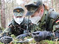 Grundausbildung in Germersheim Zwei Rekrutinnen lesen, auf auf dem Waldboden liegend, eine Karte während einer Übung bei der Grundausbildung.