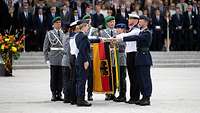 Soldaten legen mit der Hand an der Truppenfahne ihr Gelöbnis ab