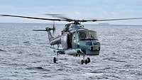 Ein Hubschrauber schwebt über dem Wasser
