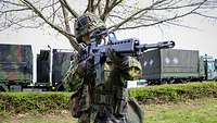 Soldat hat ein Maschinengewehr in der Hand. 