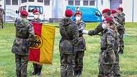 Soldaten legen ihre Hand auf die Deutschlandfahne und sprechen die Gelöbnisformel. 