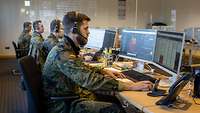Mehrere Soldaten sitzen vor Computern im Einsatz bei der Corona-Kontaktnachverfolgung.