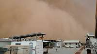 Sandsturm im MINUSMA Einsatz Eine große grau-braune Wolke zieht über Wohncontainer