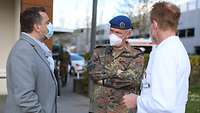 Oberbürgermeister, Generalarzt und Chefarzt unterhalten sich vor dem Klinikum