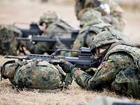 Soldaten bei der Schießausbildung auf dem Truppenübungsplatz Mehrere Soldaten liegen nebeneinander mit Gewehren im Anschlag auf dem Truppenübungsplatz