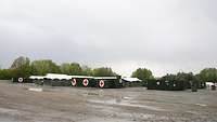 Tents and Containers on wet, gravelled ground