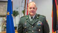 Oberst Jürgen Muntenaar Ein Soldat steht vor zwei Flaggen