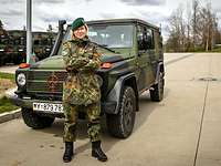 Julia Wehner as a soldier during reservist service A blonde female soldier in front of a green cross-country vehicle