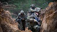 Soldaten bewegen sich durch ausgehobene Schützengräben