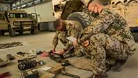 Rückverlegung aus Afghanistan Zwei Soldaten prüfen verschiedenes Material aus einem Bundeswehrfahrzeug auf Vollzähligkeit