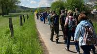 Der Pilgerzug auf dem Weg, angeführt durch einen Fahnenträger