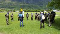 Soldaten stehen im Kreis auf einer grünen Wiese