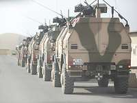 Mehrere gepanzerte Fahrzeuge vom Typ Dingo stehen hintereinander am Straßenrand im Bundeswehr-Camp