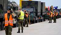 Vorbereiten der KFZ Soldatinnen und Soldaten in Warnwesten besteigen die Waggons und arbeiten an den Fahrzeugen