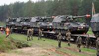 Panzerhaubitze 2000 Vier Panzerhaubitzen stehen auf Bahnwaggons. Die Besatzungen beginnen die Vorbereitungen für das Entladen