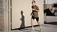 Ein Soldat in Sportbekleidung joggt in einem Feldlager in Afghanistan.