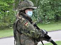 Eine Rekrutin hält ein Gewehr in der Hand