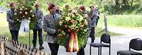Soldaten tragen Blumenkränze