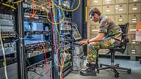 Ein ausländischer Soladt arbeitet an einem Server.
