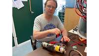 Ein Techniker schraubt am Modell einer fernzundbaren Rohrbombe.