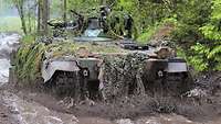Ein Schützenpanzer Marder fährt durch ein tiefes schlammiges Wasserloch 