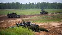 Vier Panzer fahren durch das Gelände