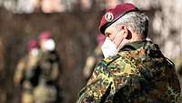 Ein General steht draußen vor einer Formation Soldaten.