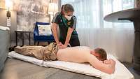 Behandlung im Hotel Eine Frau behandelt eine Person auf dem Boden. Als Unterlage wird eine dünne Matratze genutzt