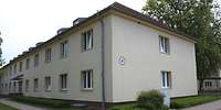 Zweigeschossiges, beiges Gebäude mit Walmdach