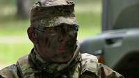 Soldat mit Tarnschminke im Gesicht.