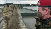 Mehrere Soldaten laufen über eine Brücke, die aus Pontons zusammengesetzt ist.