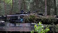 Zwei Soldaten in der Panzerluke stehend im Wald