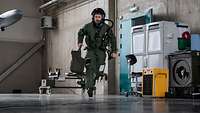 Ein Pilot der Bundeswehr rennt in einer Halle