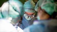 Nahaufnahme von einem Bundeswehr-Arzt mit Lupenbrille während einer Operation