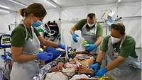 Medizinisches Personal bereitet im Feldhospital einen Verwundeten auf eine Operation vor